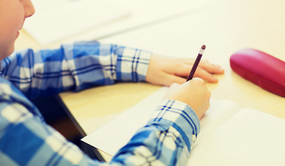Image showing close up of schoolboy writing test at school