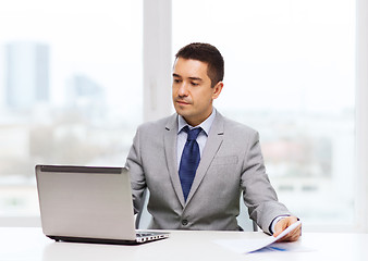 Image showing businessman with laptop and papers