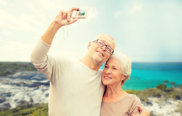 Image showing senior tourists couple with camera photographing