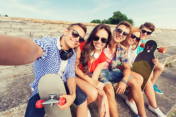 Image showing group of smiling friends with smartphone outdoors