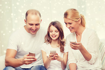 Image showing happy family with smartphones at home