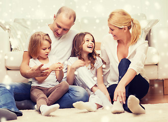 Image showing smiling parents and two little girls at home