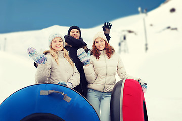 Image showing group of smiling friends with snow tubes