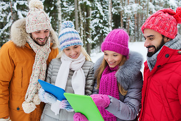 Image showing smiling friends with tablet pc in winter forest