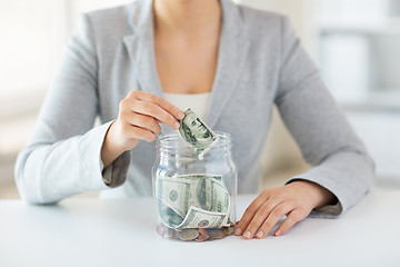 Image showing close up of woman hands and dollar money in jar