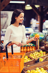 Image showing happy young woman with food basket in market