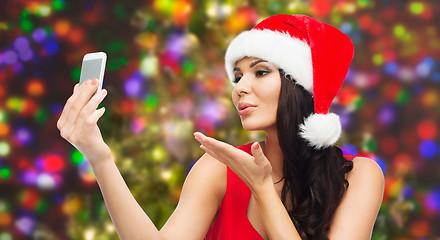 Image showing woman in santa hat taking selfie by smartphone