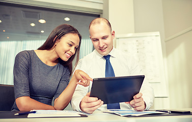 Image showing smiling businesspeople with tablet pc in office