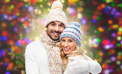 Image showing happy couple in winter clothes hugging over lights