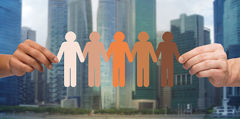 Image showing hands with people pictogram over city background