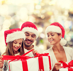 Image showing happy family in santa helper hats with gift boxes