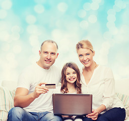 Image showing happy family with laptop computer and credit card