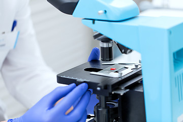 Image showing close up of hands with microscope and blood sample