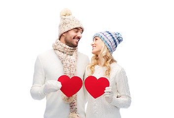 Image showing smiling couple in winter clothes with red hearts