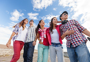 Image showing smiling teenagers in sunglasses hanging outside