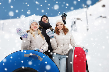 Image showing group of smiling friends with snow tubes