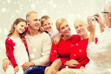 Image showing smiling family with camera photographing at home