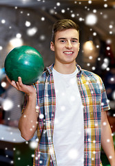 Image showing happy young man holding ball in bowling club