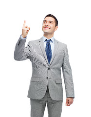 Image showing happy businessman in suit pointing finger up