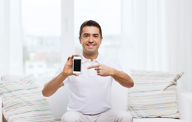 Image showing happy man with smartphone at home