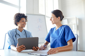 Image showing happy doctors with tablet pc meeting at hospital