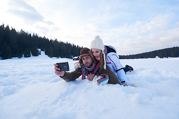 Image showing romantic couple have fun in fresh snow and taking selfie