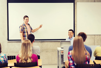 Image showing group of students and smiling teacher in classroom