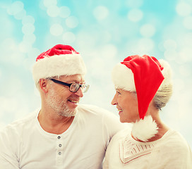 Image showing happy senior couple in santa helper hats