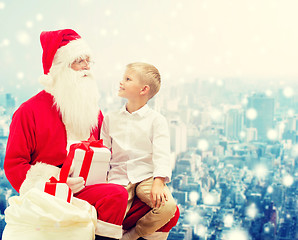 Image showing smiling little boy with santa claus and gifts