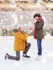 Image showing happy couple with engagement ring on skating rink