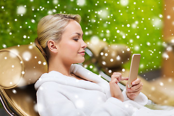 Image showing beautiful young woman with smartphone at spa