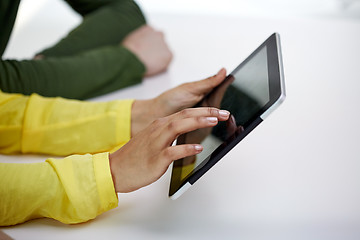 Image showing close up of female hands with tablet pc at table