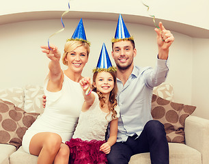 Image showing smiling family in blue hats with cake