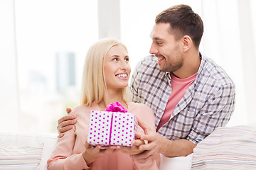 Image showing happy man giving woman gift box at home