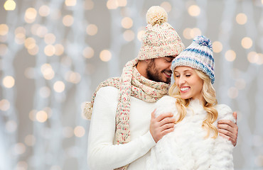 Image showing happy couple in winter clothes hugging over lights