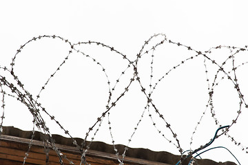 Image showing barb wire fence over gray sky