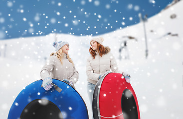 Image showing happy girl friends with snow tubes outdoors