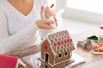 Image showing close up of woman making gingerbread house at home