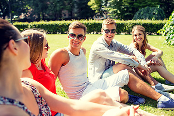 Image showing group of smiling friends outdoors sitting in park