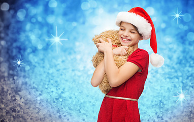 Image showing smiling girl in santa helper hat with teddy bear