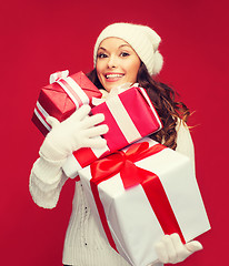 Image showing woman in sweater and hat with many gift boxes