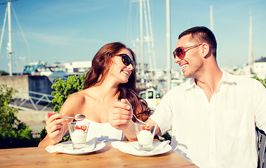 Image showing smiling couple eating dessert at cafe