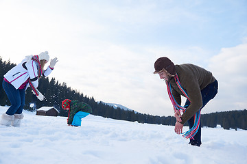 Image showing happy family playing together in snow at winter