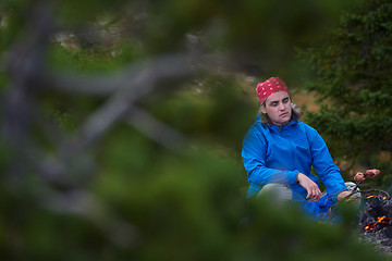 Image showing hiking man prepare tasty sausages on campfire