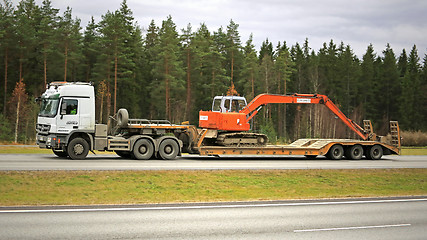 Image showing White Mercedes-Benz Truck hauls Hitachi Excavator on Motorway