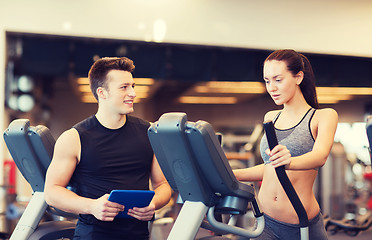 Image showing woman with trainer exercising on stepper in gym