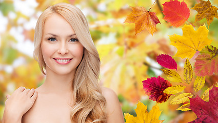 Image showing beautiful young woman face over autumn leaves