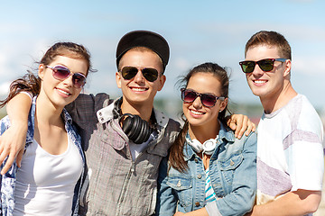 Image showing smiling teenagers in sunglasses hanging outside