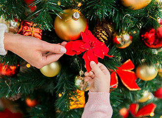 Image showing close up of family decorating christmas tree