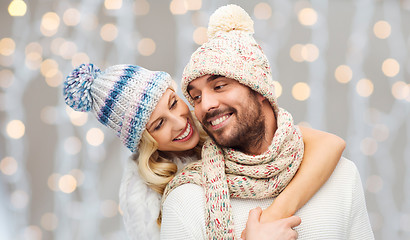 Image showing happy couple in winter clothes hugging over lights